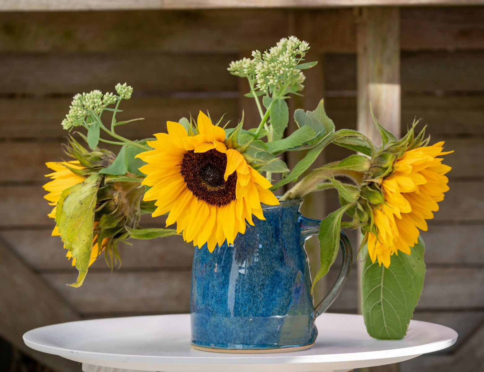 sunflower in blue glass vase