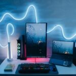 a desk with a keyboard, monitor, mouse and other items